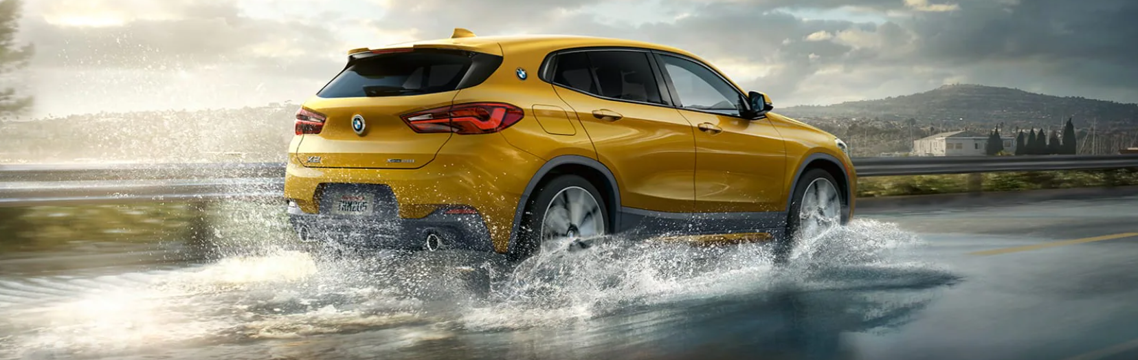 yellow BMW x2 driving through water